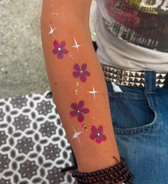 Arm painting with pink flowers and sparkle stars